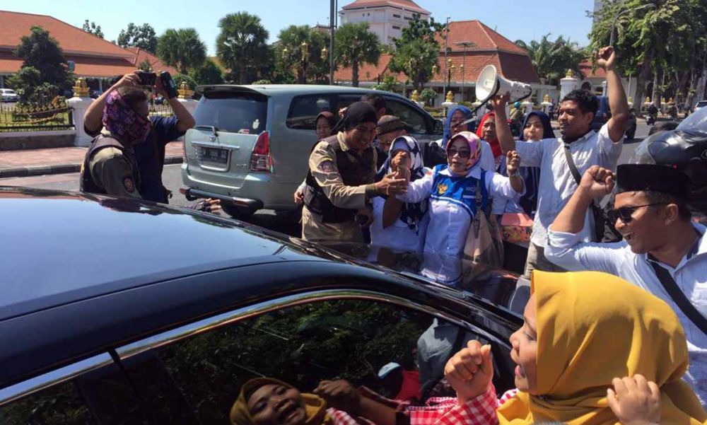 Pendemo sistem zonasi yang didominasi emak-emak menghadang mobil berplat merah di Jalan Gubernur Suryo, Surabaya