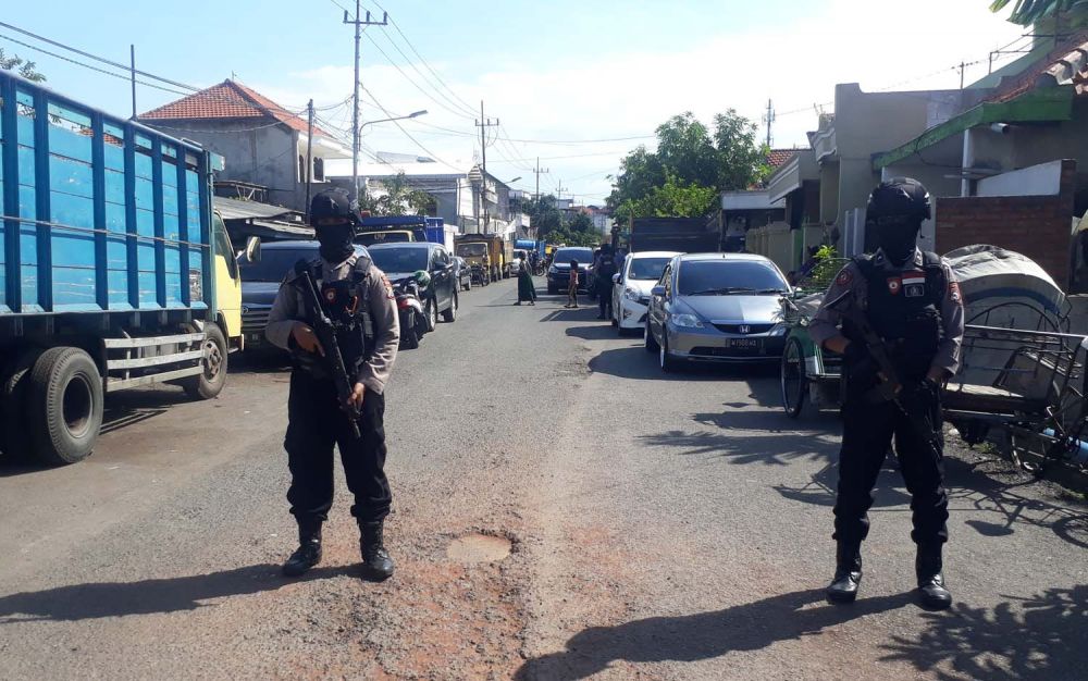 Sejumlah polisi bersenjata laras panjang berjaga di sekitar gudang ekspedisi Jalan Kunti No. 72, Surabaya tempat kerja terduga teroris (Foto: Zain Ahmad/jatimnow.com)