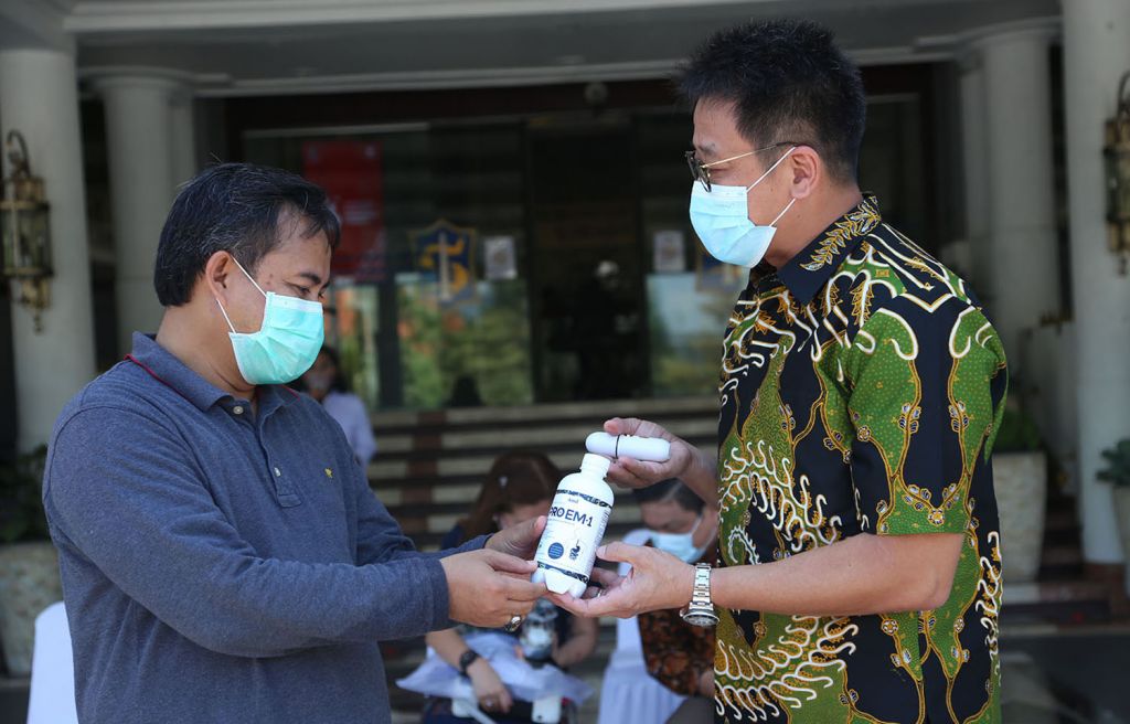 Direktur PT AMA, Ge Recta Geson (kanan) menyerahkan bantuan secara simbolis kepada Asisten Perekonomian dan Pembangunan Surabaya M Ikhsan