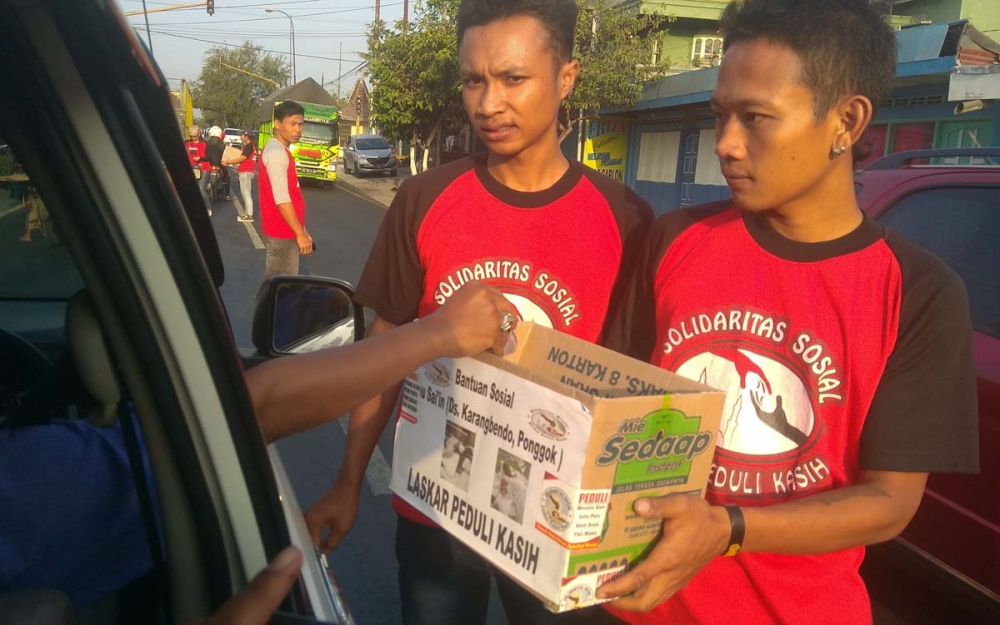 Para pemuda menggalang donasi dari pengguna jalan untuk Sai'in, ibu yang dibacok anak kandungnya di Blitar