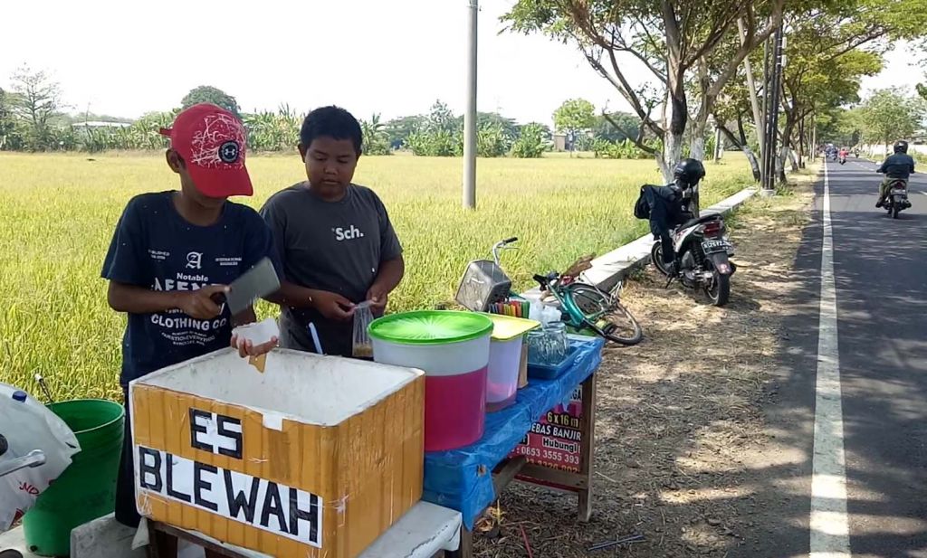 Ibrahim dan Rizki saat berjualan es blewah (Foto: Moch Rois/jatimnow.com)