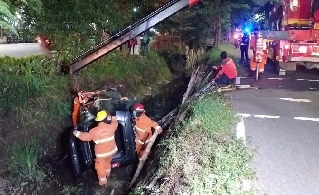 Proses evakuasi mobil Calya yang terporosok ke parit jalan di Surabaya