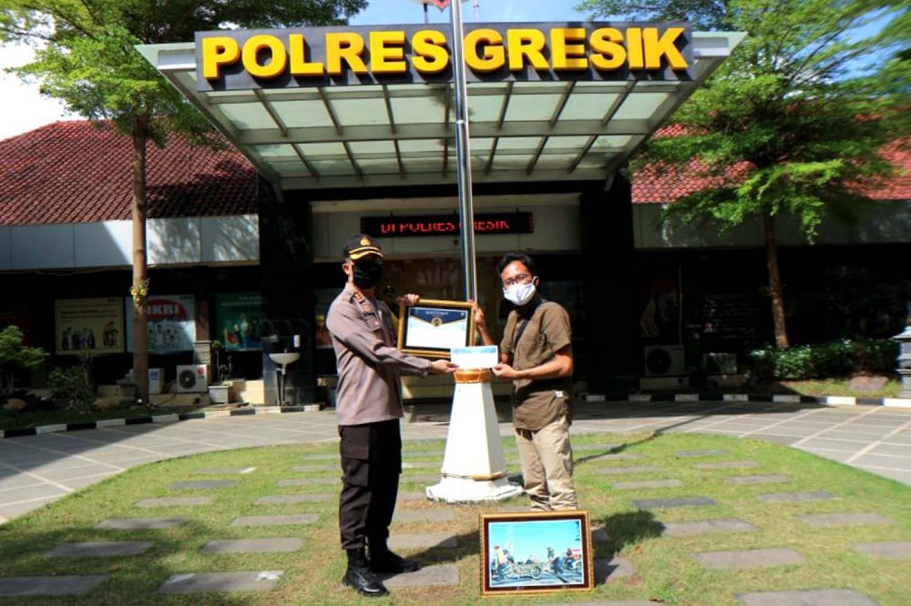Kapolres Gresik AKBP Kusworo Wibowo memberikan penghargaan untuk pemenang lomba foto 'Polisi bermanfaat' kepada juara 1 Fajar Mujianto