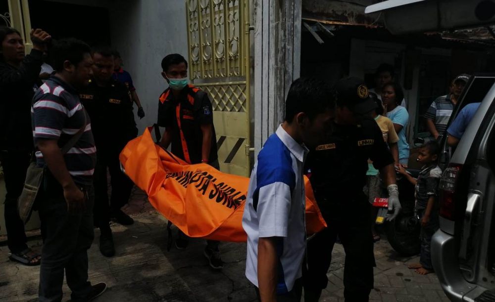 Petugas mengevakuasi jasad korban dari rumahnya di Jalan Rangkah Rejo 3 No.14, Tambaksari, Surabaya