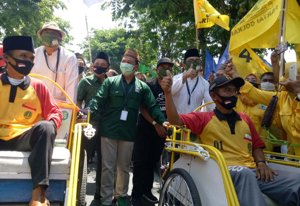 Gus Ipul-Adi Wibowo mengayuh becak wisata menuju Kantor KPU Kota Pasuruan