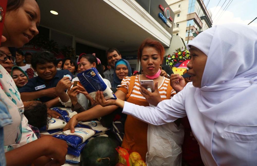 Gubernur Khofifah memberikan gula gratis kepada ratusan warga usai membuka Pasar Buah dan Gula Murah yang digelar jatimnow.com dan PIOS di kantor jatimnow.com, Jalan Jimerto 17A, Surabaya