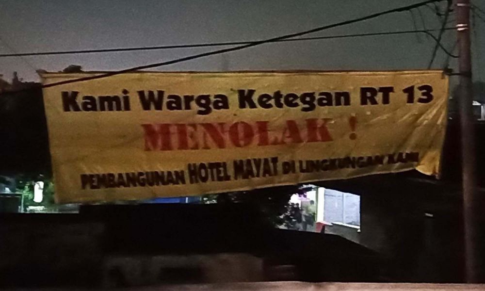 Spanduk penolakan pembangunan Hotel Mayat terpasang di dekat Pintu Gerbang Tol Waru (Foto-foto: Budi Sugiharto/jatimnow.com)