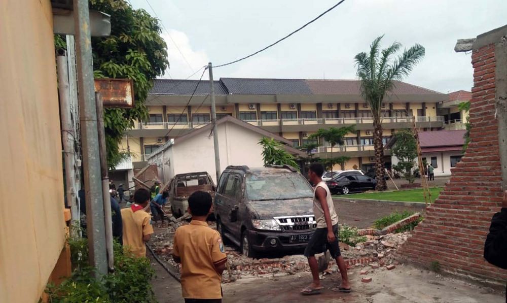 Dua mobil yang tertimpa tembok Gedung Universitas Islam Blitar akibat hujan angin