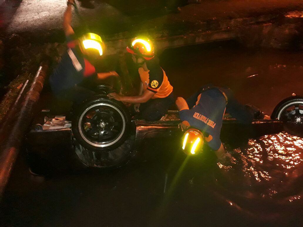 Petugas melakukan evakuasi mobil yang nyebur ke sungai.