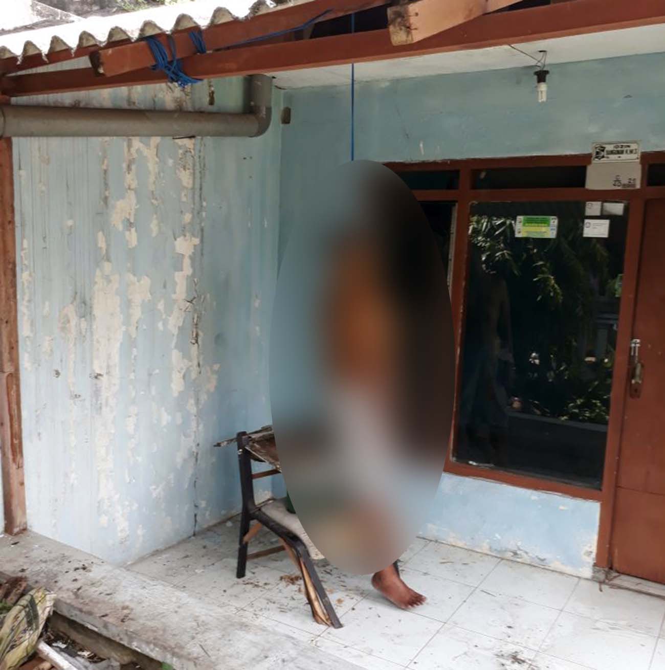 Jenazah Made saat pertama kali ditemukan di teras rumahnya.