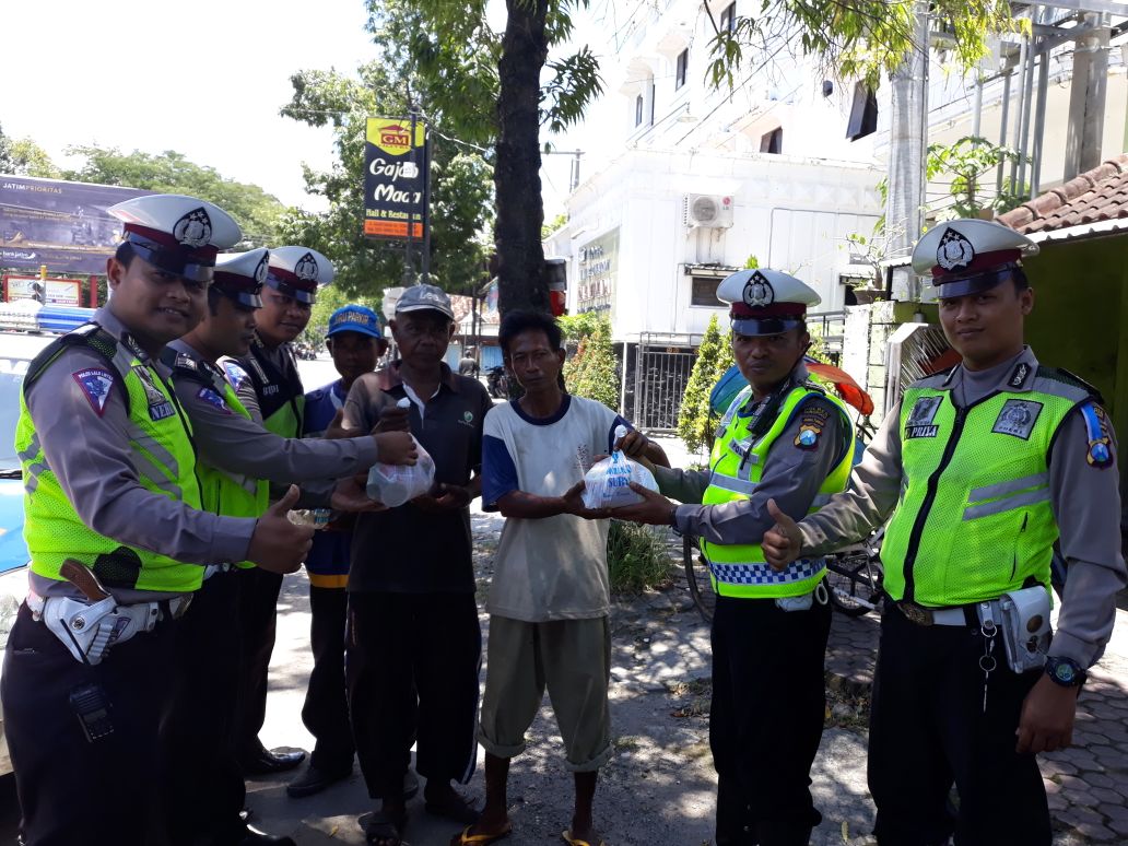 Sat Lantas Polres Ponorogo membagi-bagikan sembako kepada tukang becak.