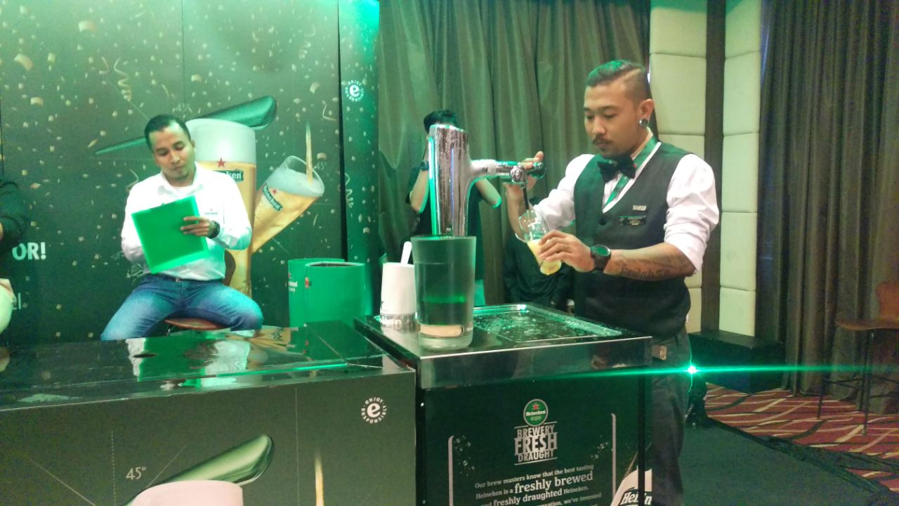 Salah satu peresta sedang unjuk kebolehan menuang bir di ajang pencarian bakat bartender di Surabaya.