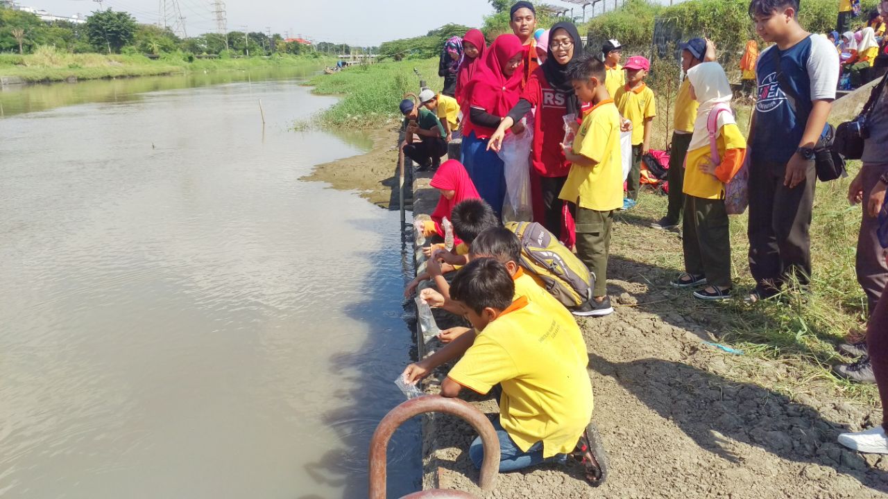 Para siswa SD Alam Insan Mulia saat menebar benih ikan di sungai Jagir