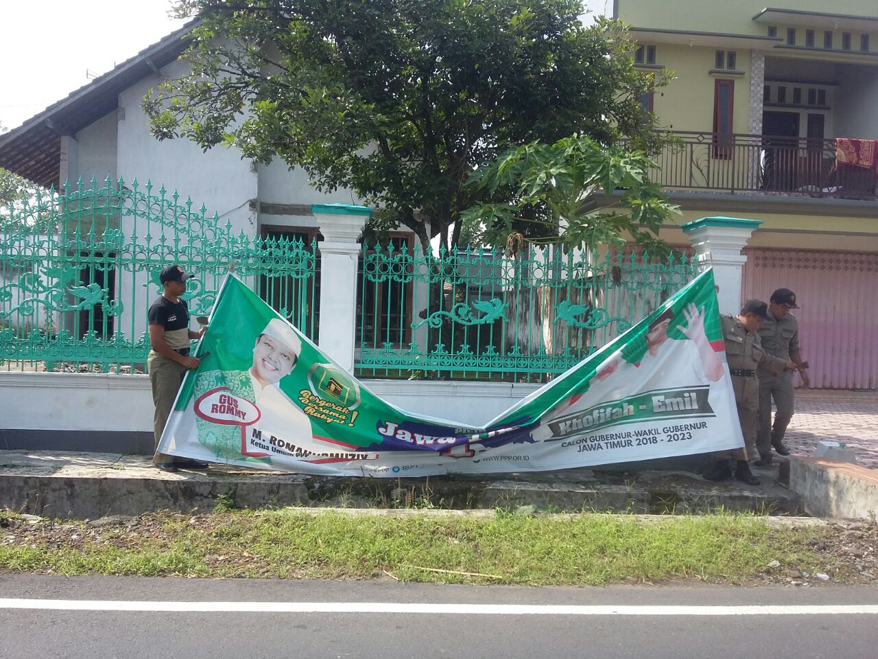 Petugas mencopoti banner