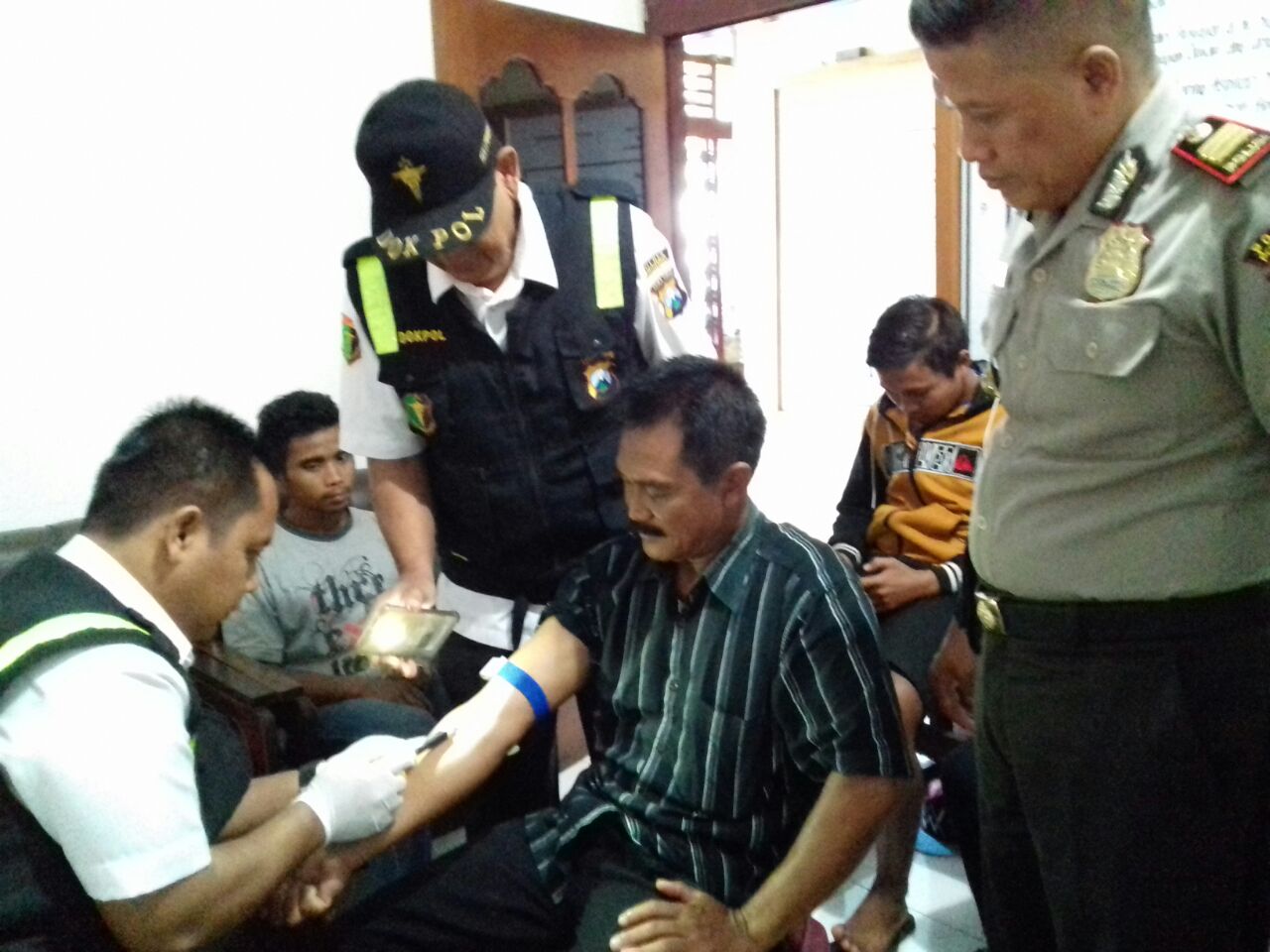 Petugas mengambil sampel darah salah satu warga.