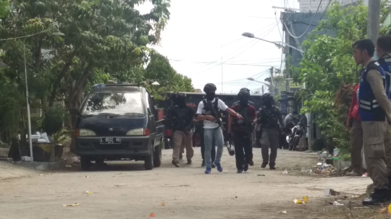 Petugas menggledah rumah bomber di Medokan Ayu Surabaya.
