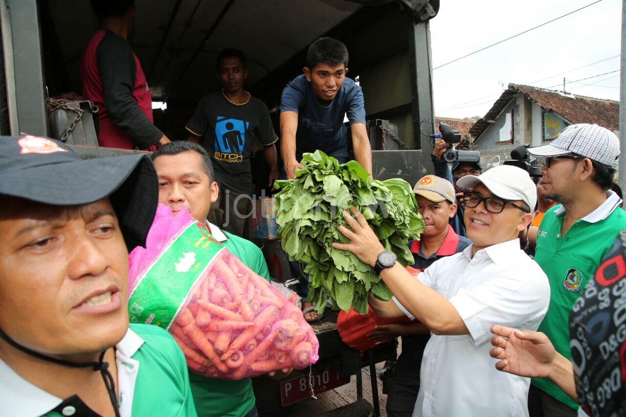 Bupati Anas saat membantu relawan di lokasi banjir./Foto: Humas for jatimnow.com.