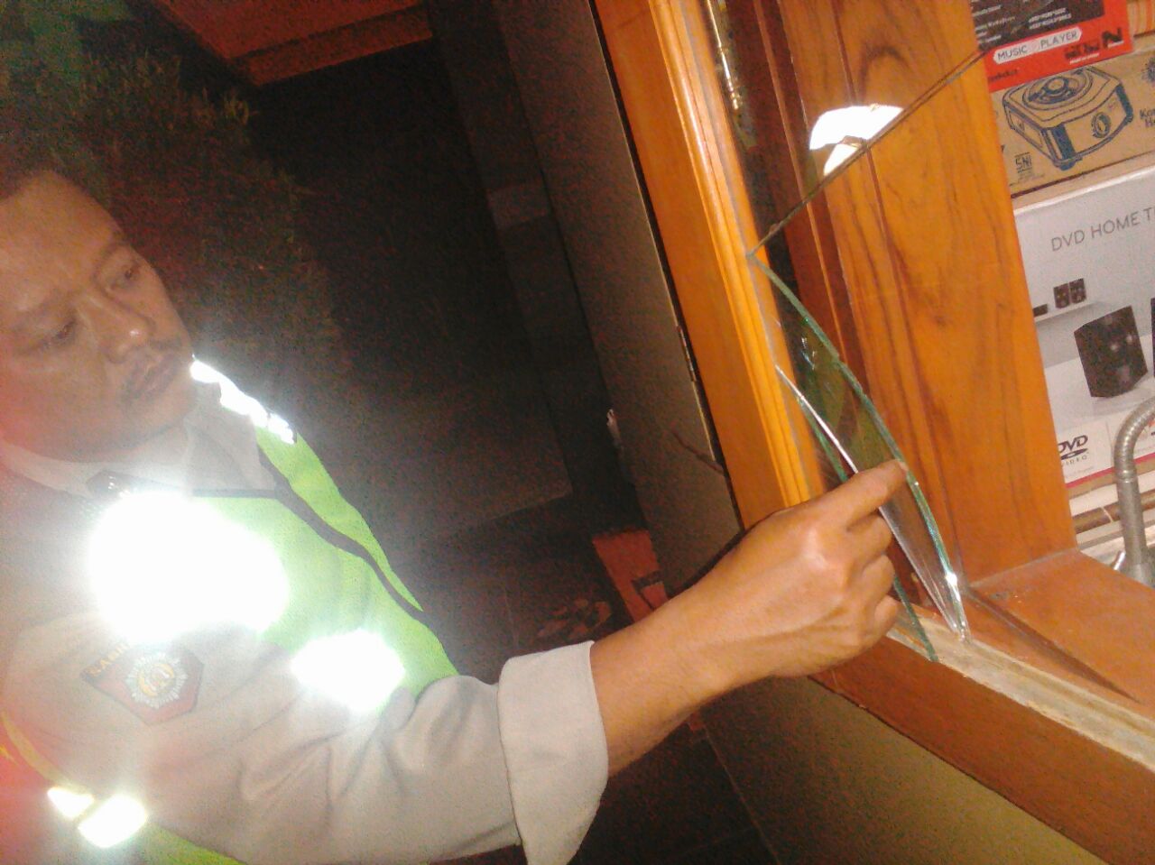 Petugas menunjukkan kaca yang pecah