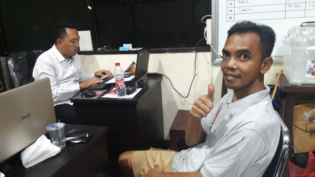 Salah satu pejudi togel tersenyum saat difoto oleh petugas Satreskrim Polres Banyuwangi