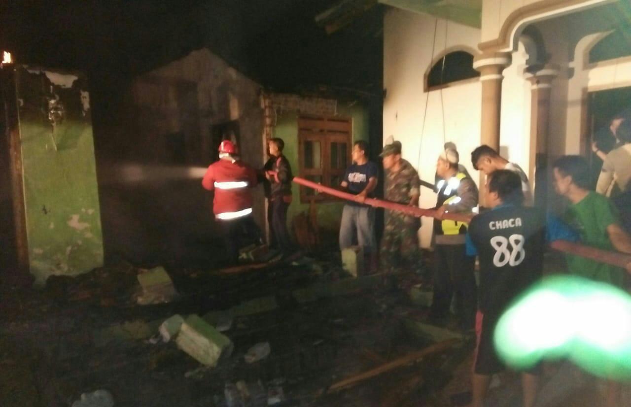 Petugas dan warga memadamkan api