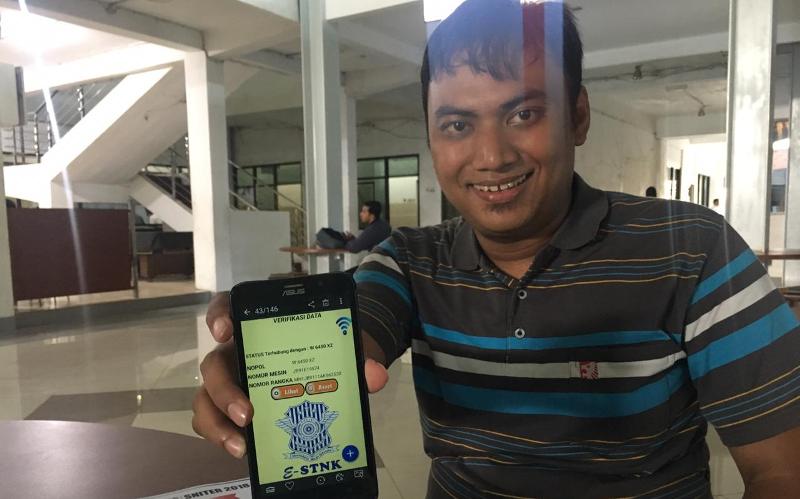 Mahasiswa Universitas Narotama Surabaya Achmad Rizal menunjukkan E-STNK yang dibuatnya.