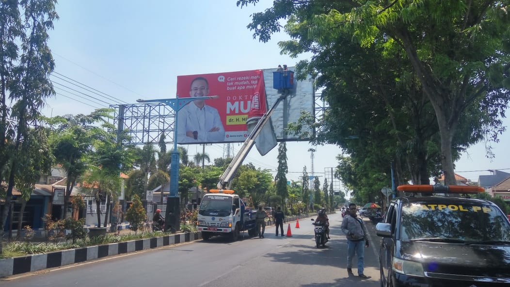  Petugas menurunkan reklame liar di Kraksaan, Kabupaten Probolinggo/Foto: Mahfud Hidayatullah/jatimnow.com