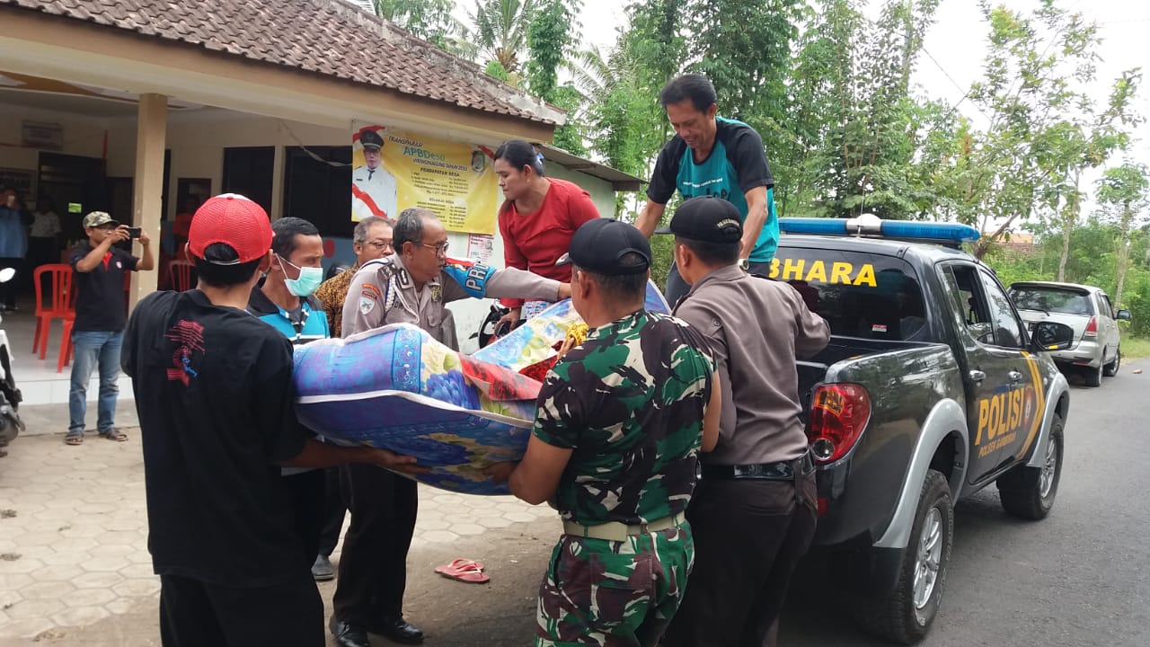 Polisi dan warga bergotong royong mengangkut warga yang terserang penyakit.