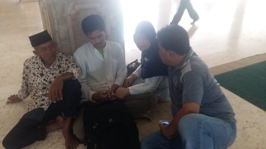 Rivan mengenakan kemeja putih 