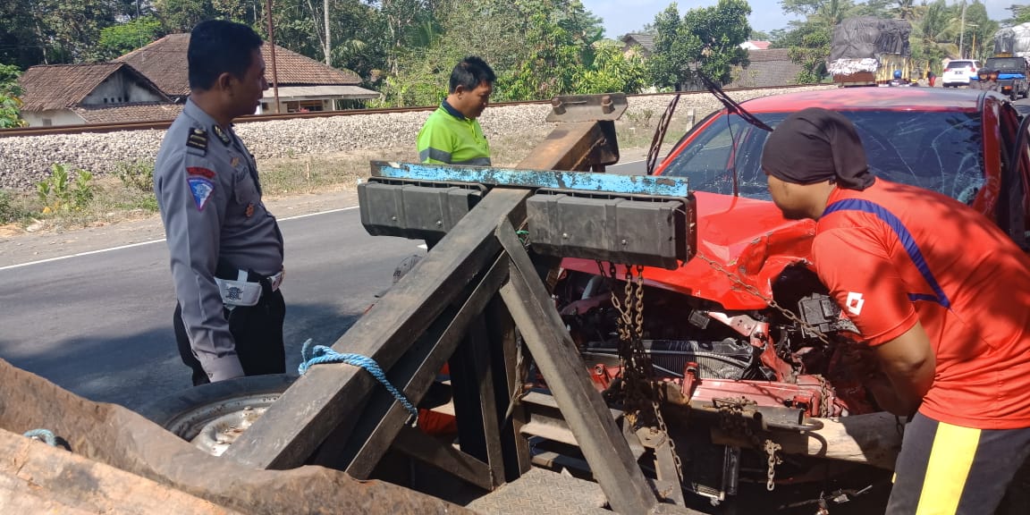 Petugas saat menderek mobil Honda Jazz yang ringsek.