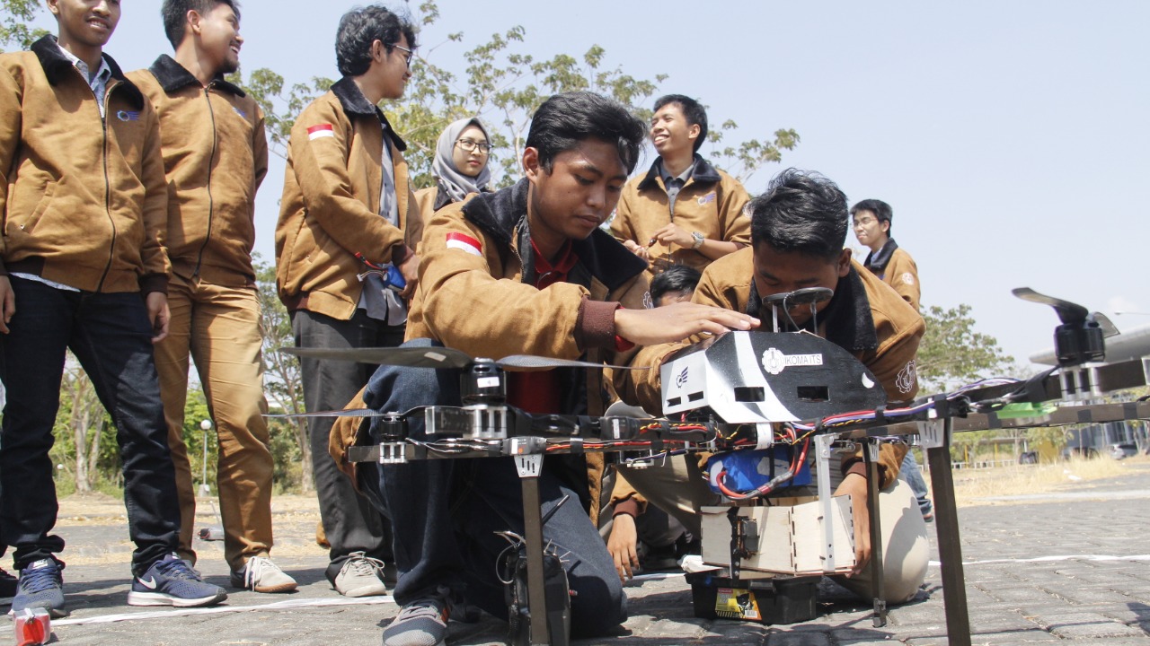 Tim ITS saat mencoba robotnya.