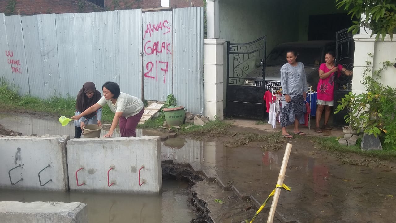 Warga Gunung Anyar saat mengambil air bersih di saluran PDAM yang bocor

