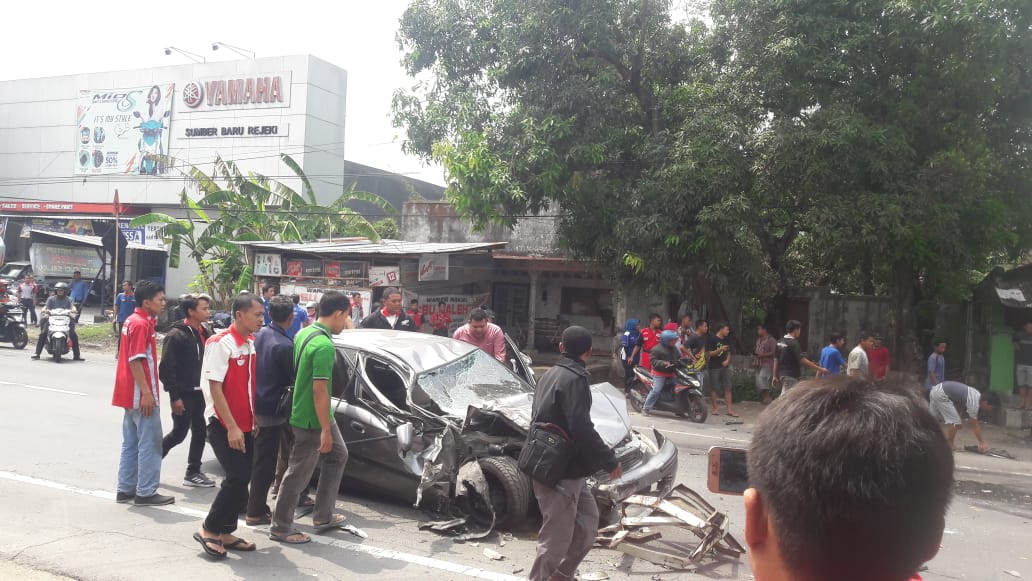 Warga dan polisi mengevakuasi mobil yang rusak akibat kecelakaan dengan truk (Istimewa)