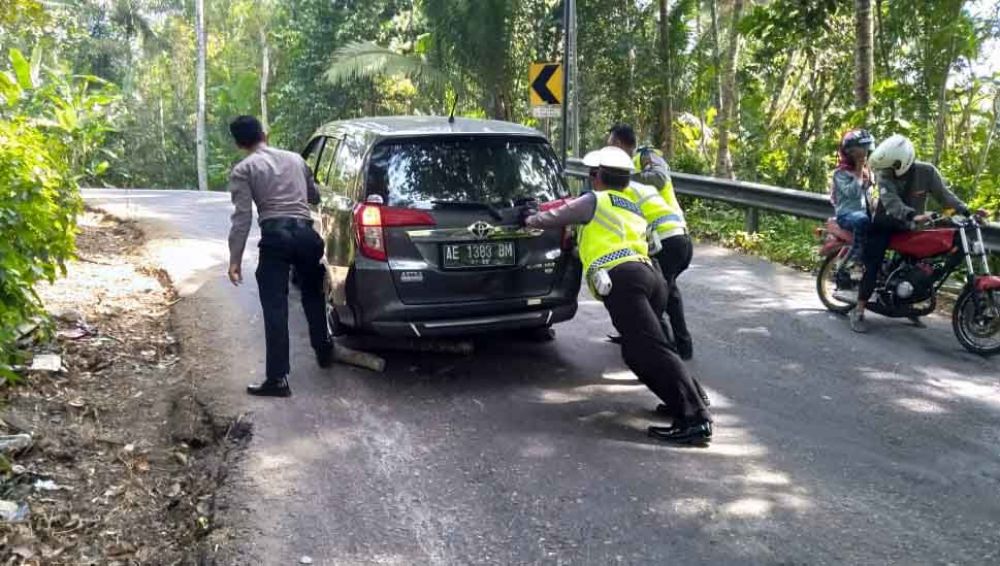 Polisi mendorong mobil di jalur Sedeng, Pacitan