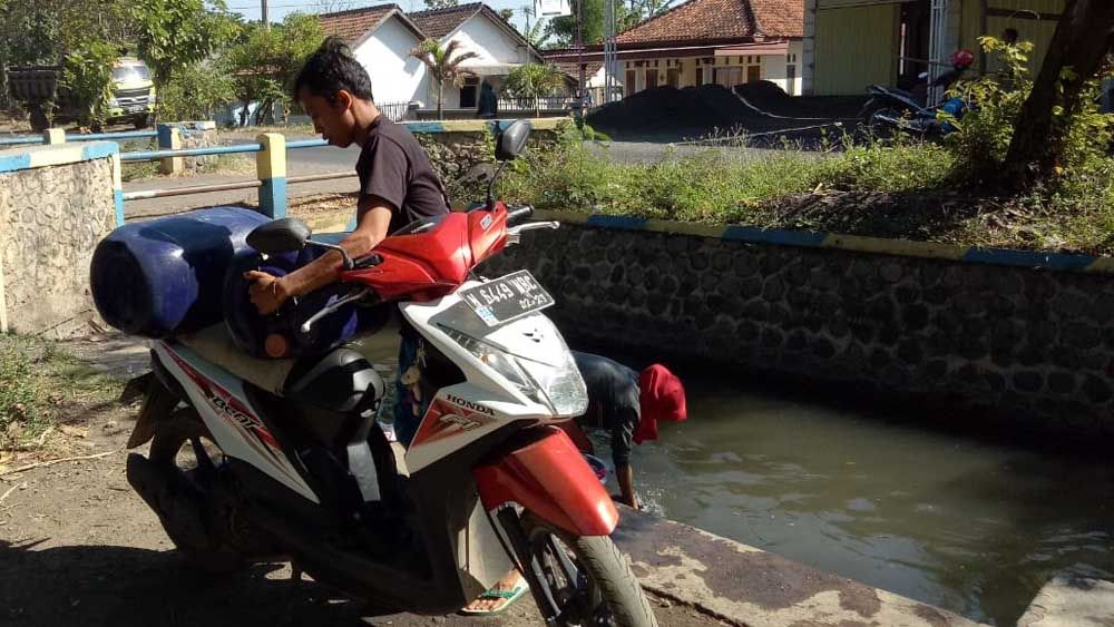 Warga Probolinggo mengambil air yang dipergunakan untuk kebutuhan sehari-hari