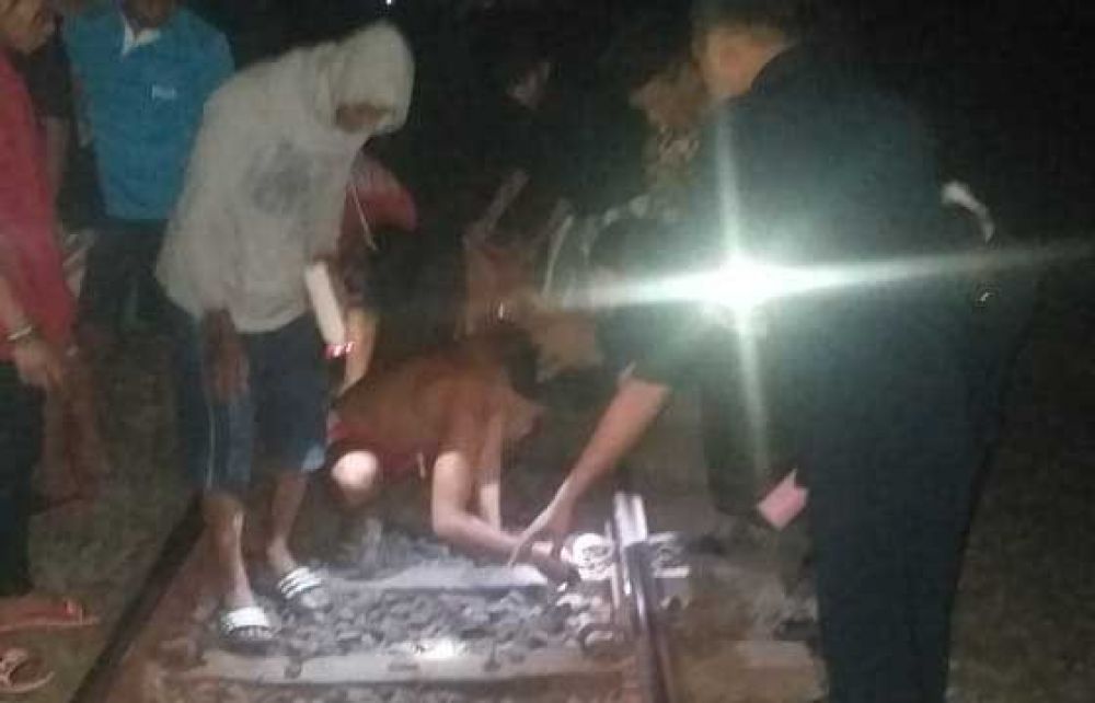 Warga dan petugas membersihkan tubuh korban yang tewas setelah menabrakan diri ke kereta api