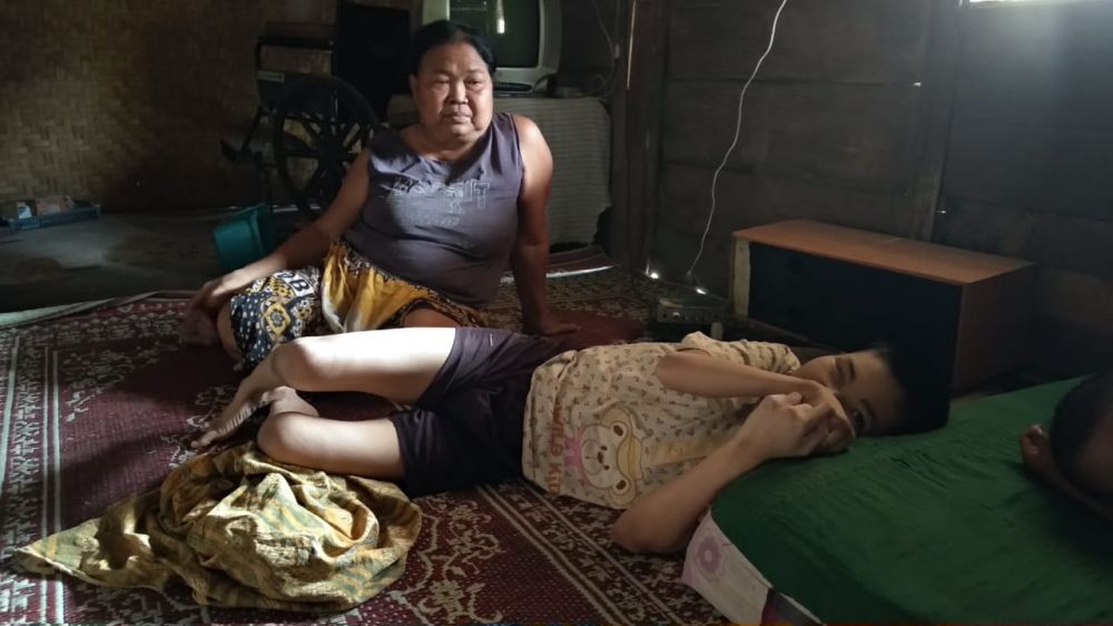 Suyati merawat anaknya yang menderita lumpuh dan ibu kandungnya seorang diri