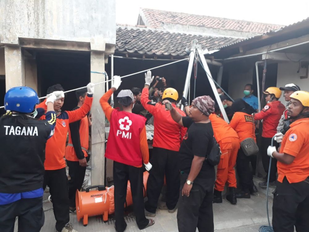 Petugas mengevakuasi jenazah korban dari dalam sumur
