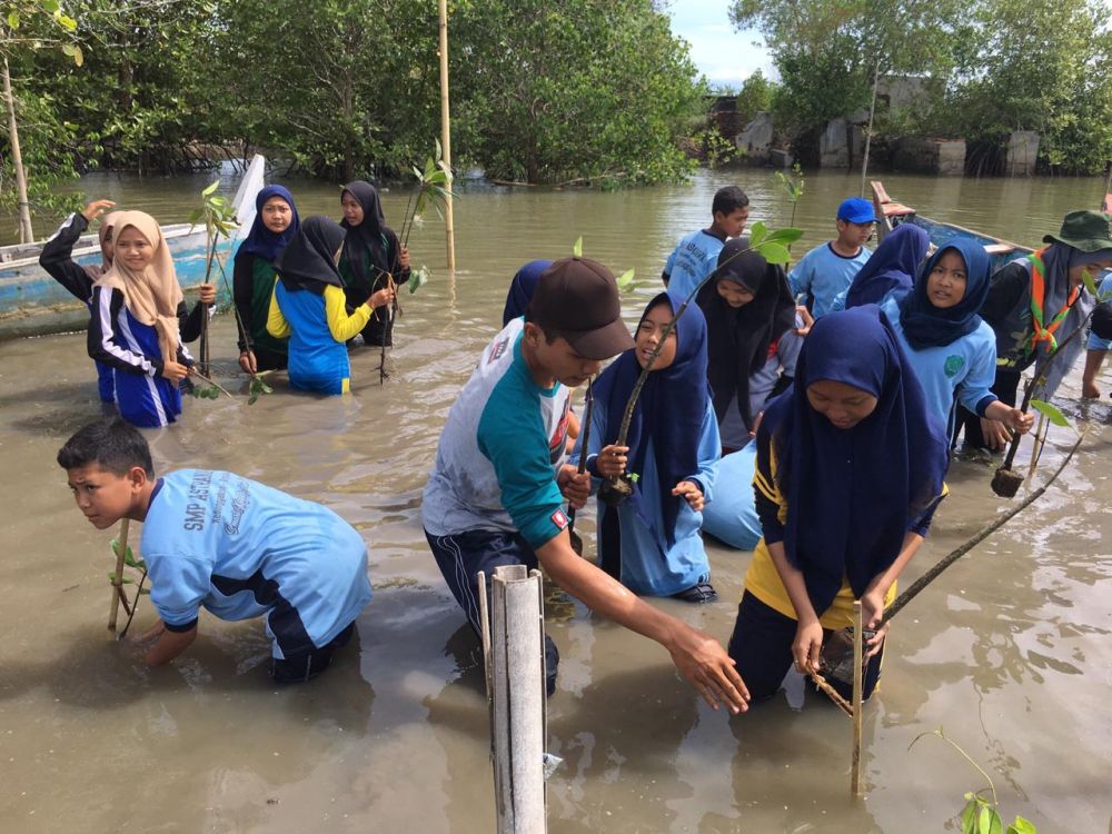 Para pelajar hingga kelompok nelayan menanam 1000 pohon mangrove di pesisir Desa Kedunggebang, Kecamatan Tegaldlimo, Kabupaten Banyuwangi