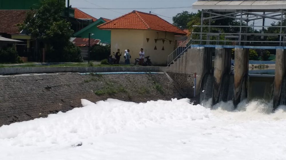 Busa yang terlihat menumpuk di sungai Desa Sumput, Sidoarjo