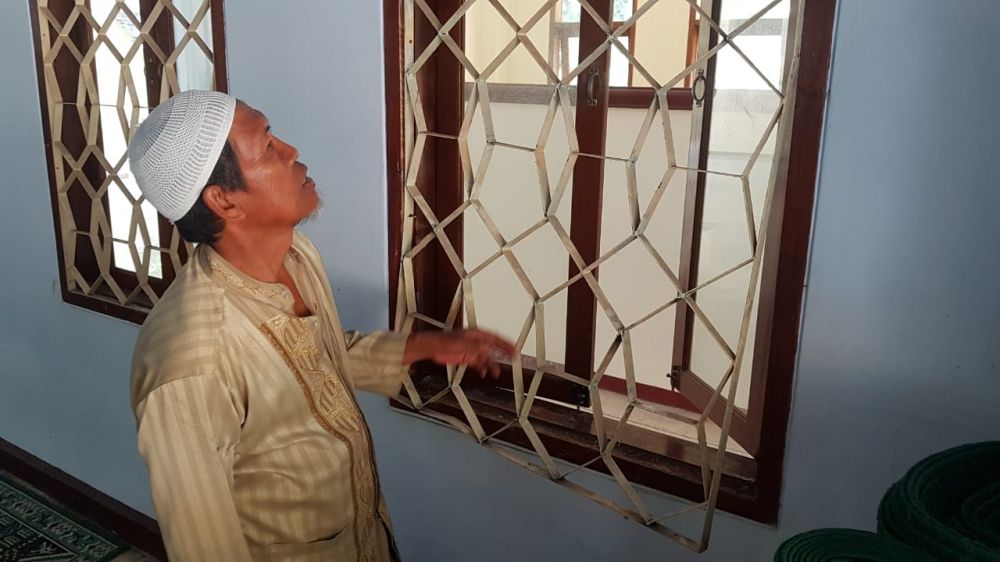 Takmir menunjukkan teralis besi jendela masjid yang dicongkel pelaku pencurian uang kotak amal