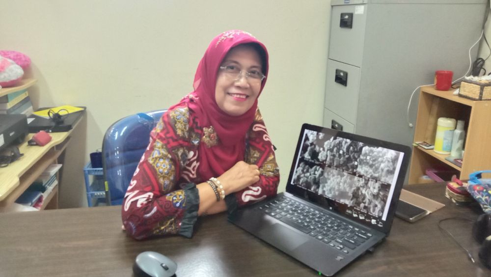 Dr Dra Enny Zulaika M P menunjukkan laporan penelitiannya 