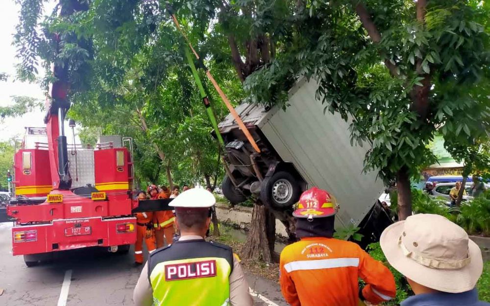 PMK Kota Surabaya mengevakuasi mobil boks yang tercebur ke sungai