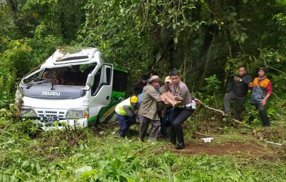 Polisi dan warga mengevakuasi korban kecelakaan di Banyuwangi