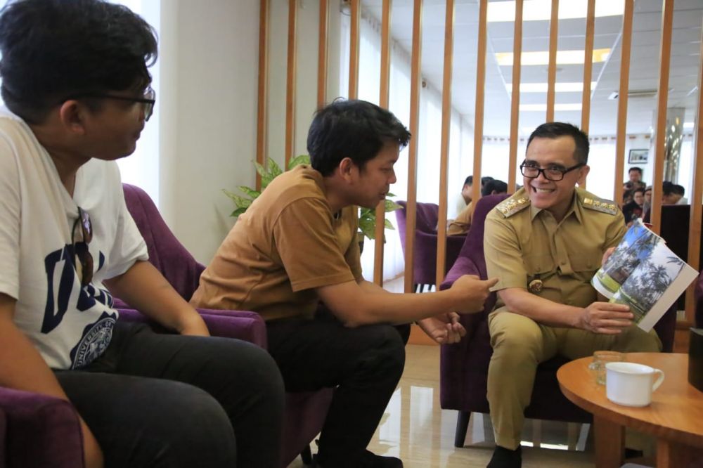 Bupati Anas menunjukkan foto-foto keindahan alam Banyuwangi kepada pemeran utama Film 'Yowes Ben 3' Bayu Skak dan Sutradara Fajar Nugros 