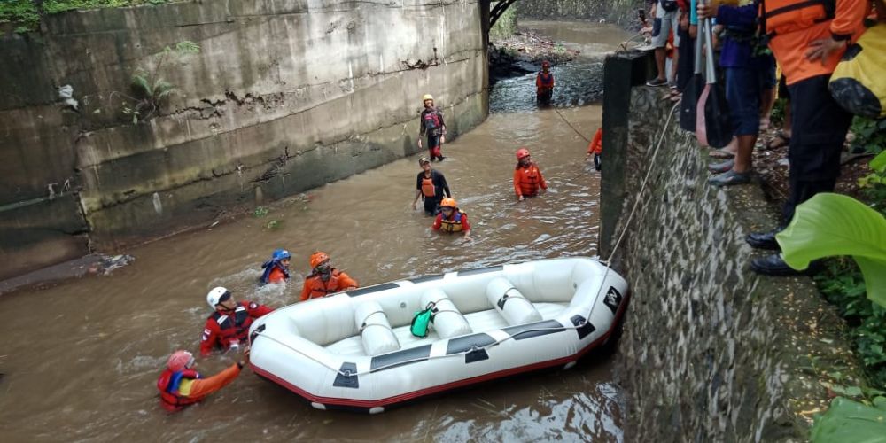 Tim gabungan menggunakan perahu karet untuk mencari dua santri yang hanyut dalam sungai di Malang