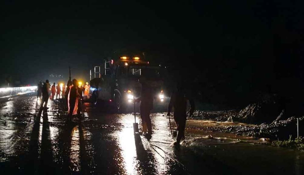 Petugas membersihkan longsoran tebing di Tol Pandaan-Malang