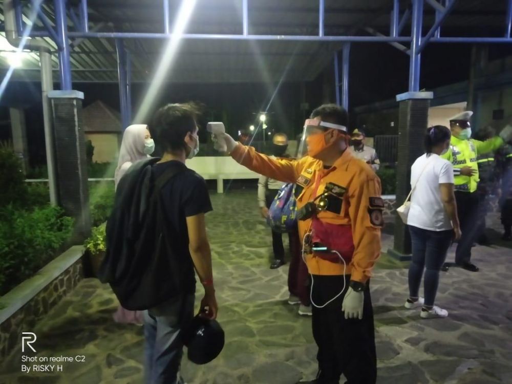 Petugas melakukan pemeriksaan pada para pekerja migran yang datang