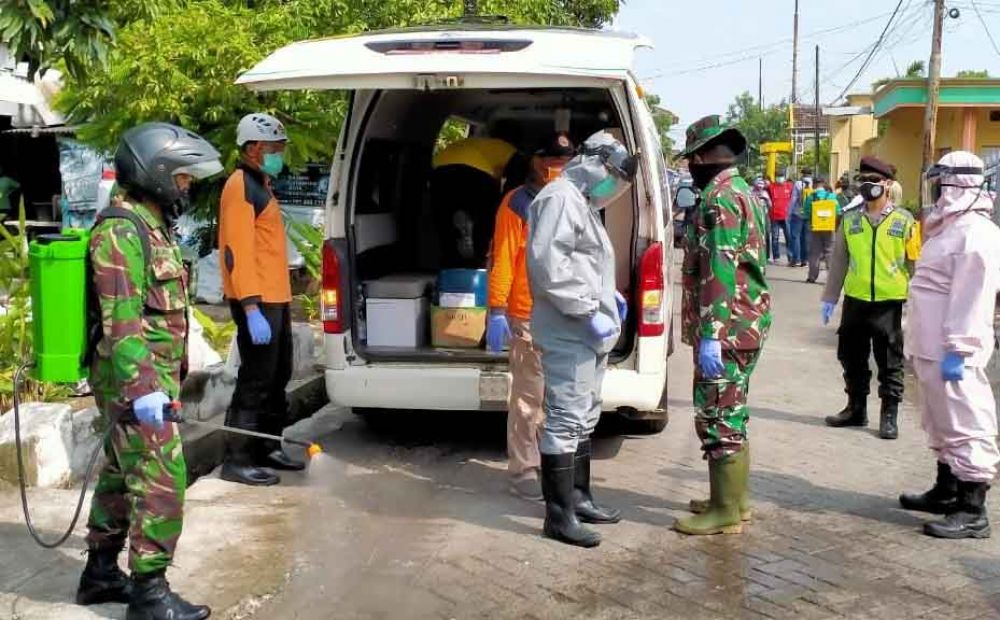 Petugas melakukan penyemprotan disinfektan di Dusun Gresikan, Beji, Pasuruan setelah ada pasien Covid-19 kabur