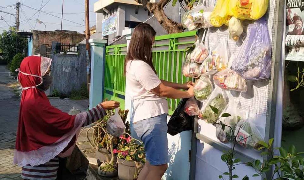 Warga mengambil bantuan yang dicantolkan di kawat