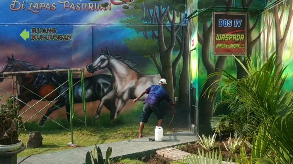 Edy Siswanto alias Edy Tato melukis dinding Lapas Klas IIB Pasuruan